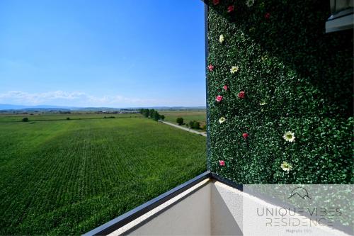 a view of a green field with flowers on a building at FLH - Unique Vibes Residence Magnolia Sibiu in Sibiu