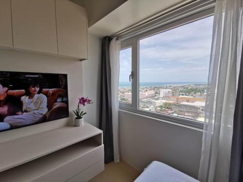 a room with a large window with a view of the city at Avida Davao by davaobnb & Lemonique Homes in Davao City