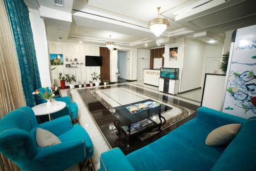 a living room with blue furniture and a swimming pool at Gold Palace in Termiz