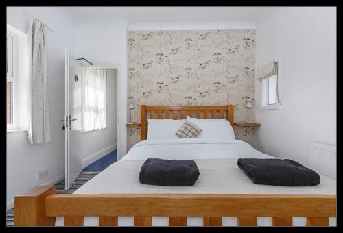 a bedroom with a large bed with two pillows on it at Overcliff Lodge, Mundesley sea view, sleeps 22 in Mundesley