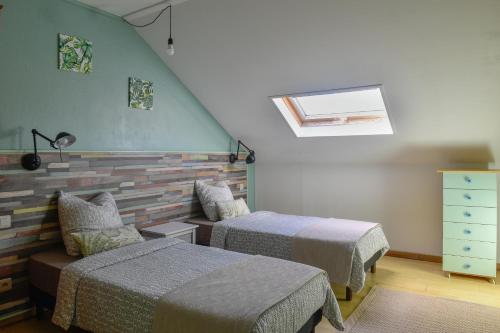 1 dormitorio con 2 camas y tragaluz en Le Rubinjo - Appartement d'hôtes en Saint-Benoît