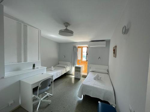 a white room with two beds and a desk at Deluxe Las Marinas Beach in Maspalomas