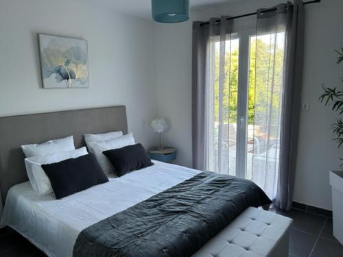 une chambre avec un grand lit et une fenêtre dans l'établissement Villa Coquelicot avec piscine privée et borne électrique, à Moussac