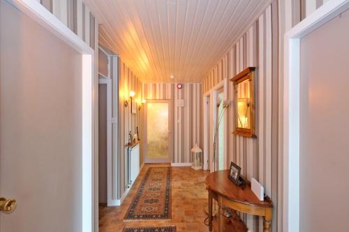 a hallway with pink walls and a wooden table at The Jays Guest House in Aberdeen