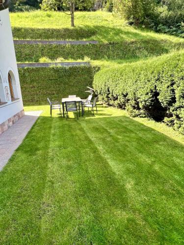 a patio with a table and chairs in the grass at Residence Palmai in Ortisei