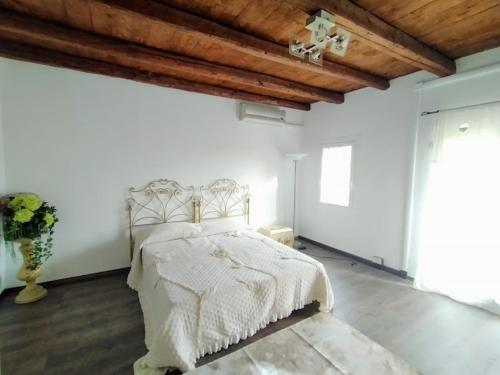 ein Schlafzimmer mit einem weißen Bett und einer Holzdecke in der Unterkunft B&B Lory's Dream in Fontanafredda