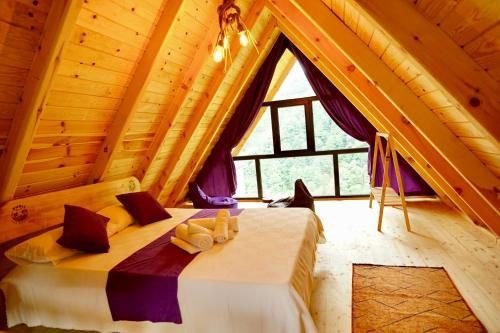 a bedroom with a bed in a wooden cabin at PUSLİ DAĞ EVLERİ in Rize