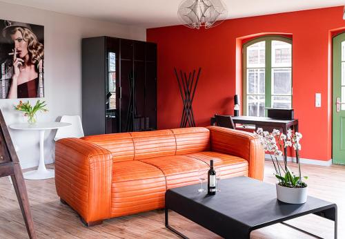 a living room with a leather couch and red walls at SEA YOU in Klink