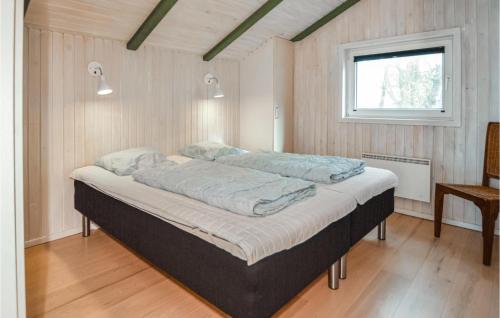 Cama grande en habitación con ventana en Stunning Home In Blvand With Sauna, en Blåvand