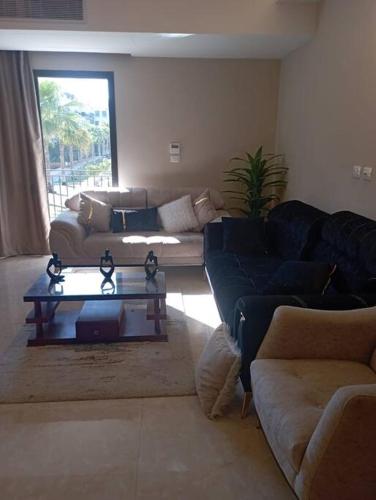 a living room with two couches and a coffee table at بيفرلي هيلز ويست تاون الشيخ زايد in Sheikh Zayed