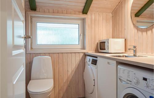 cocina pequeña con lavadora y ventana en Stunning Home In Blvand With Sauna, en Blåvand