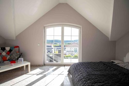 ein Schlafzimmer mit einem Bett und einem großen Fenster in der Unterkunft Komplette Luxuriöse Villa mit fantastischer Aussicht 1000 qm Garten 10 min nach Saarbrücken in Oeting