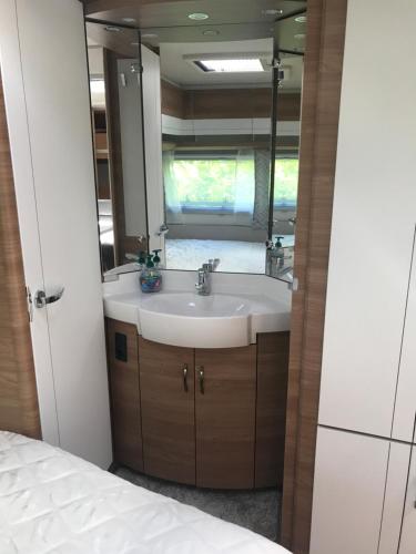 a bathroom with a sink and a mirror at Asuntovaunu Hobby in Syöte