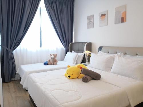 a bedroom with two beds with stuffed animals on them at Hanns&FreeWIFI&Washer+Pool@SunshineComfortHMStay3 in Sibu