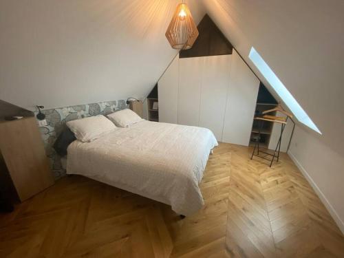 1 dormitorio con cama blanca y suelo de madera en Proche Paris et Disney, maison avec piscine sauna, en Sucy-en-Brie