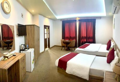 Cette chambre comprend deux lits et une télévision. dans l'établissement Sheek Hotel, à Erbil