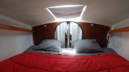 Vintage Sailboat in Belém في لشبونة: سرير في غرفة صغيرة مع نافذة