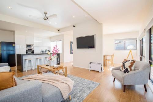 a living room with a couch and a tv at 'Swan Cottage' Port Stephens Waterfront Solace in Newcastle