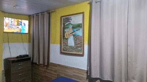 une chambre avec une peinture d'une femme sur le mur dans l'établissement Quitinete Expominas Suite e Ar, à Belo Horizonte