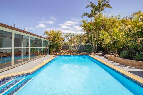 a swimming pool in front of a house at 'Villa Mayakoba' Tropical Oasis with Pool and Cabana in Newcastle