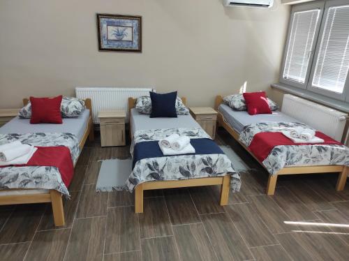 Zimmer mit 3 Betten und Kissen darauf in der Unterkunft Valor Apartmani Kikinda in Kikinda