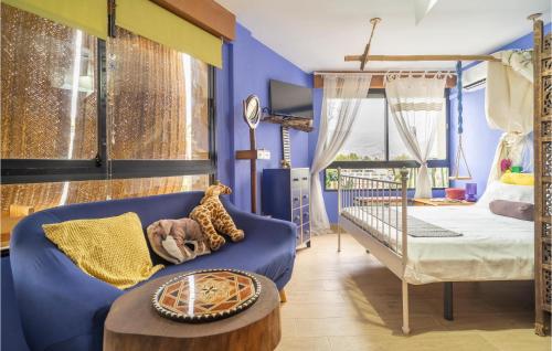 1 dormitorio con paredes azules, sofá azul y cama en Casa Montero, en Salobreña