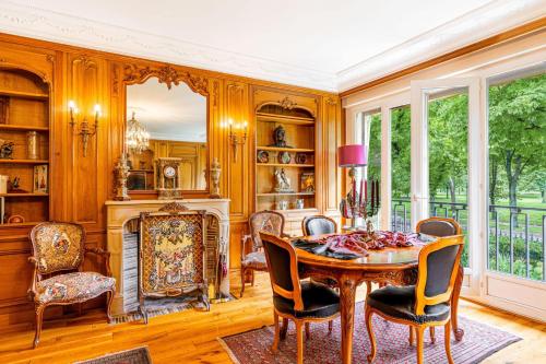 a dining room with a table and chairs and a fireplace at GuestReady - Séjour de Charme à Neuilly in Neuilly-sur-Seine