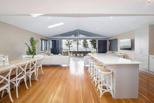 a kitchen and living room with a table and chairs at 'Stockton Grande' A Sublime Beachfront Family Oasis in Newcastle