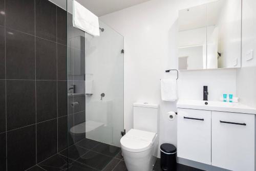 a white bathroom with a toilet and a shower at 'Highpoint Lookout' A Cool Charlestown Square Abode in Charlestown