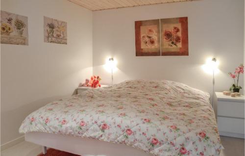 a white bedroom with a bed with a floral bedspread at Lovely Home In Esbjerg V With Wifi in Esbjerg