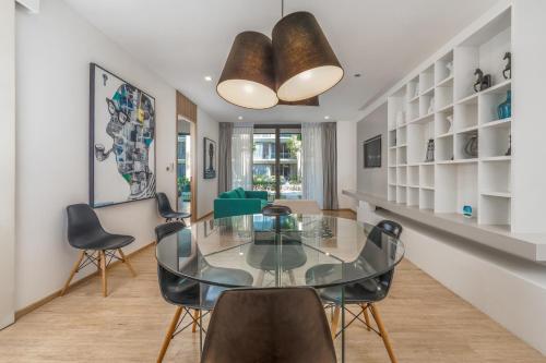 a dining room with a glass table and chairs at Baan Mai Khao apartments Phuket in Mai Khao Beach