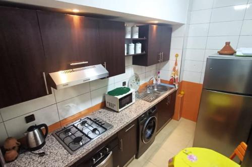 a small kitchen with a stove and a sink at Chez Noufissa in Marrakesh