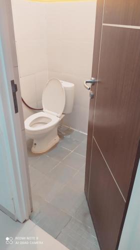 a bathroom with a toilet with the door open at Villa Permata Garden Blok D11 Near JTP 3 in Batu
