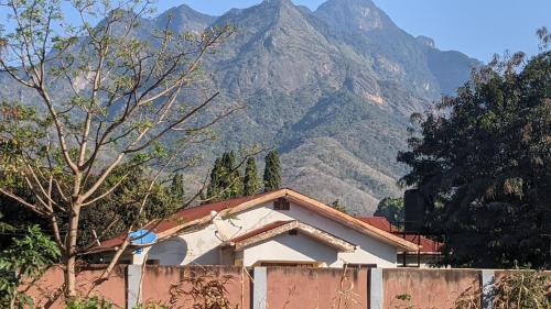 a house with a fence in front of a mountain at Kinyanjui's Homes 001 with WiFi in Morogoro