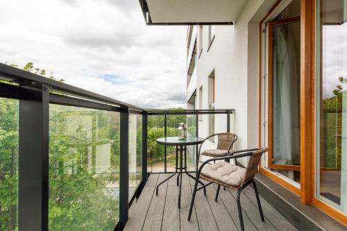 a room with a balcony with a table and chairs at Apartment Harmonia Oliwska by Renters in Gdańsk