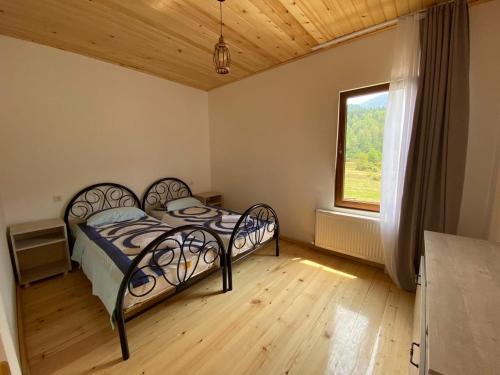 a bedroom with a bed in a room with a window at Cottage Qel in Mestia