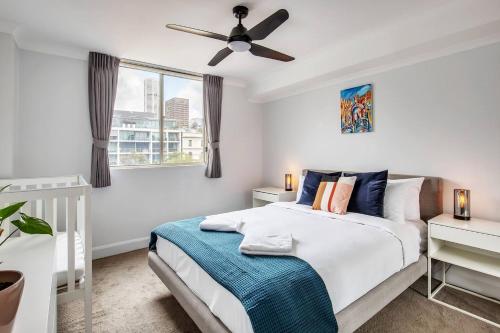 a bedroom with a bed and a ceiling fan at Harbourside at Woolloomooloo with Balcony Views in Sydney