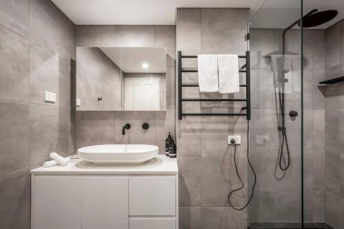 a bathroom with a sink and a shower at Harbourside at Woolloomooloo with Balcony Views in Sydney