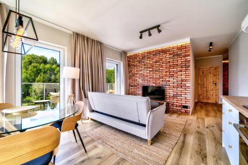 a living room with a couch and a brick wall at Nautica Resort in Giżycko