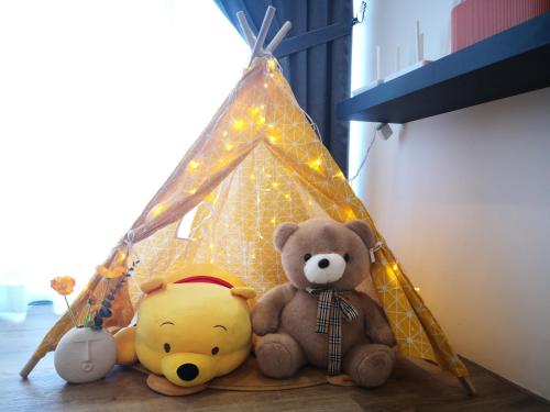 two stuffed teddy bears sitting next to a tent at Hanns&FreeWIFI&Washer+Pool@SunshineComfortHMStay3 in Sibu