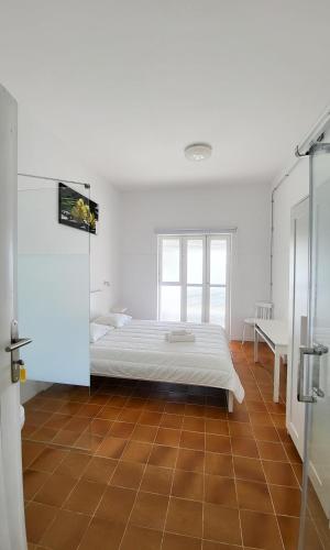 a bedroom with a bed and a tiled floor at Las Eras Nest Hostel in Las Eras