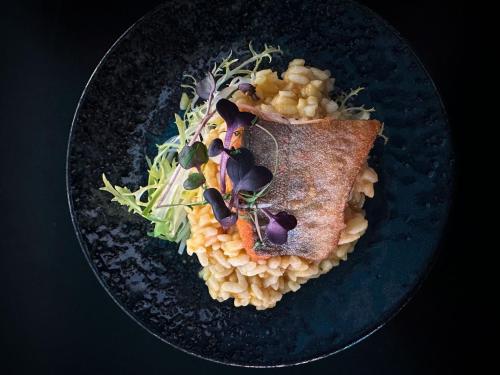 a plate of food with corn and a piece of fish at Hit the Sky in Sankt Christoph am Arlberg