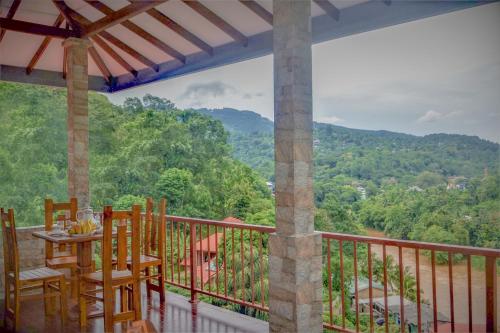 einen Balkon eines Hauses mit einem Tisch und Stühlen in der Unterkunft Rock Edge Residence in Kandy