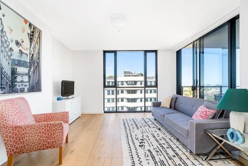 a living room with a couch and a chair at Bright Rockdale Escape near Bayside Beaches in Sydney