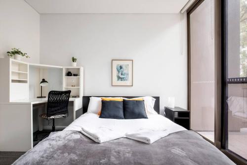 a bedroom with a bed with a desk and a chair at 'The Patio' Live like a Local in Spacious Comfort in Sydney