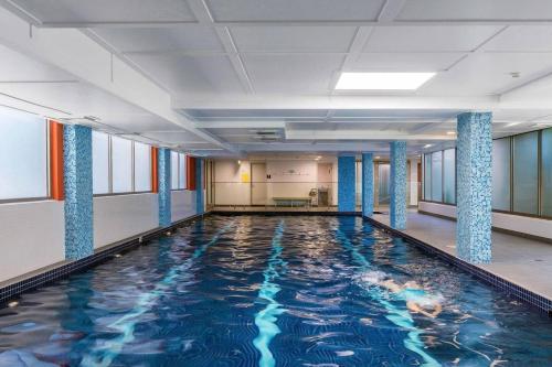 a swimming pool in a building with blue columns at 'The Patio' Live like a Local in Spacious Comfort in Sydney