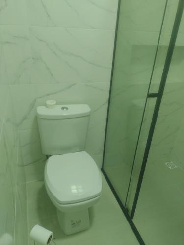 um WC branco numa casa de banho com uma parede de vidro em Flavio Baterias em Blumenau