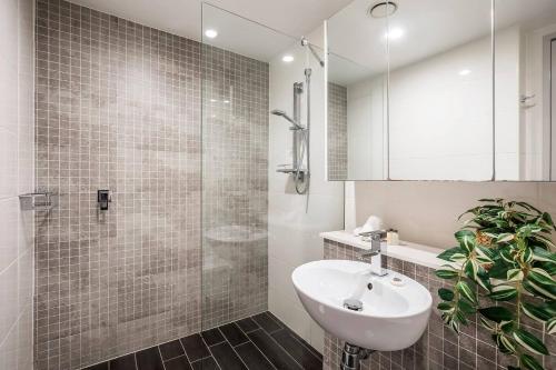 La salle de bains est pourvue d'un lavabo et d'une douche. dans l'établissement 'The Patio' Live like a Local in Spacious Comfort, à Sydney