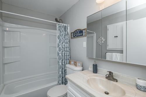 y baño con lavabo, aseo y espejo. en 3 Bedroom Haven of Rest-5 Minutes from Mayo Clinic!, en Rochester