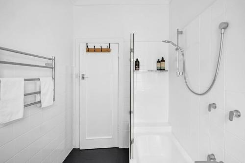 een badkamer met een douche en een glazen deur bij 'Beachside Bliss' Heart of the Coastal Lifestyle in Sydney